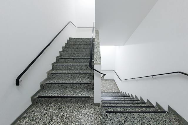 a white stairwell with grey flooring