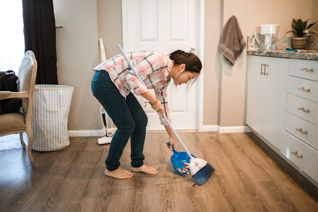 person sweeping up in a living room
